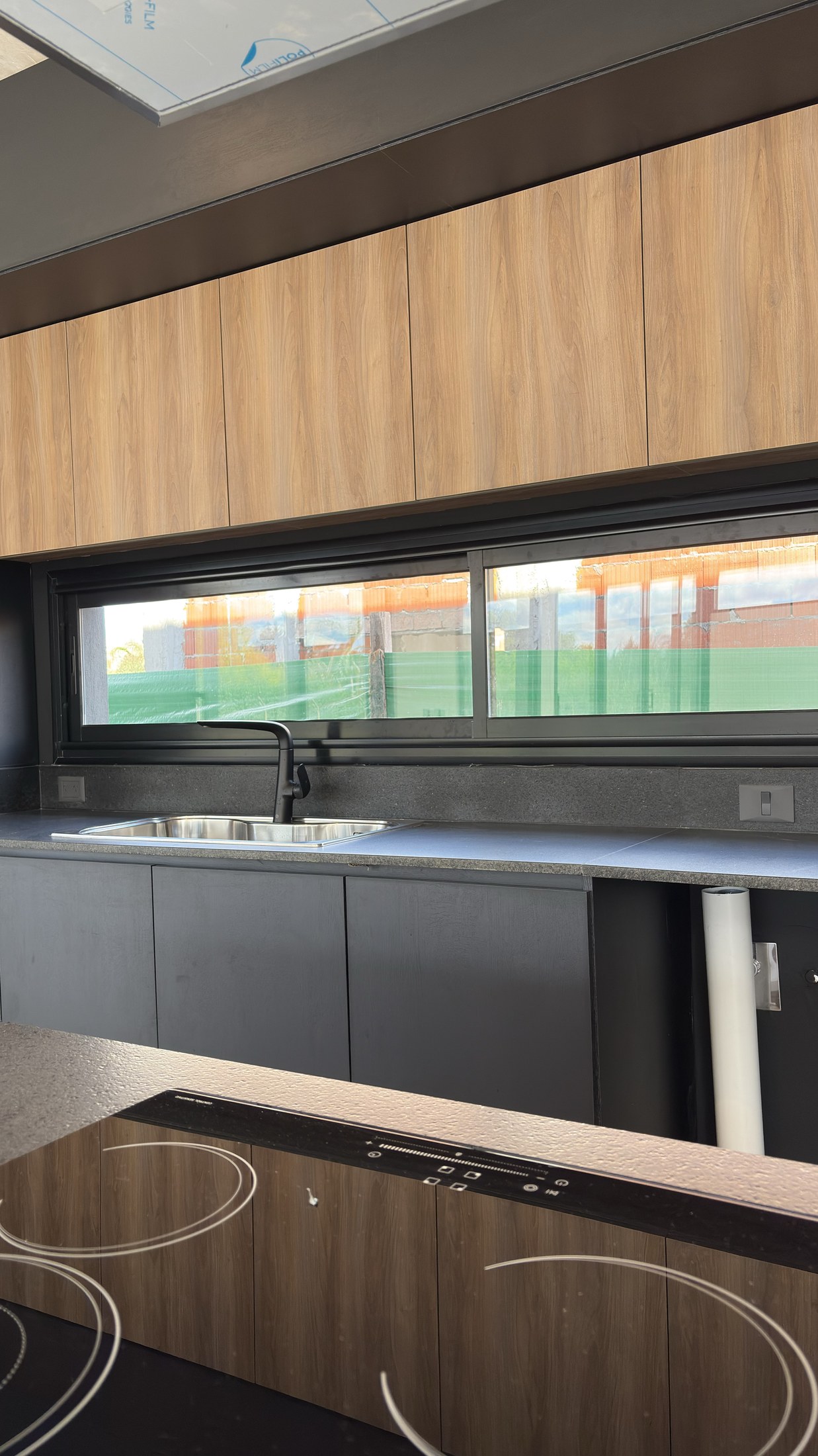 Ventana horizontal de aluminio negro en la cocina de Cardos 145