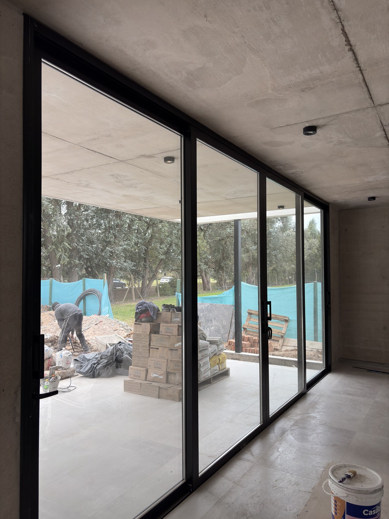 Abertura corrediza de aluminio negro y vidrio en la obra residencial Cardos 76